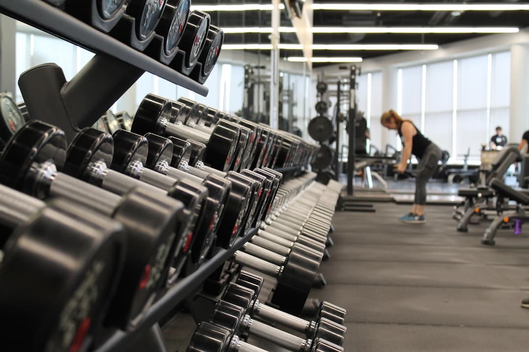 Athlète concentrée sur un squat à la barre en salle